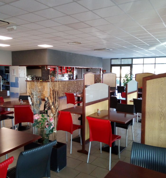 Salle de restaurant avec bar et tables à l’Hôtel L’Escale
